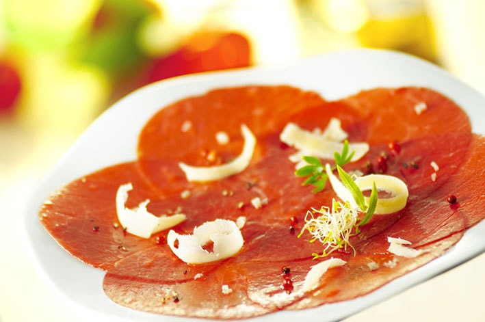 Rinder-Carpaccio mit gerösteten Samen und Nüssen, würzigem Olivenöl, Rucola-Salat mit Cidre-Dressing - 